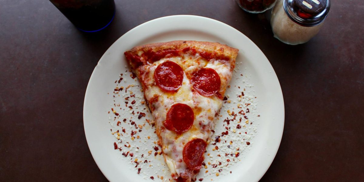 sliced pepperoni pizza on white ceramic plate